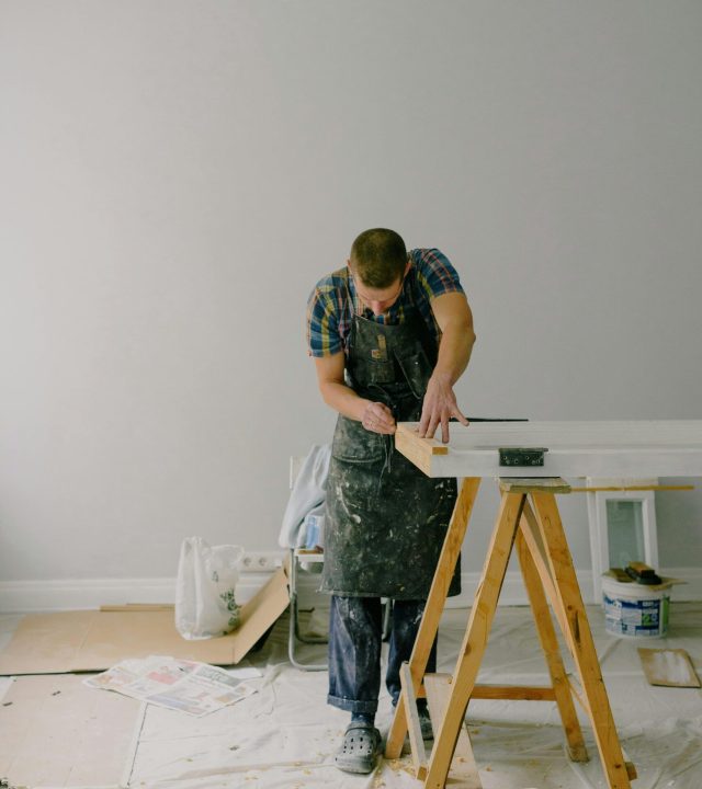 pexels-photo-5691553-5691553 Craftsman focusing intently on creating wooden furniture in an indoor workshop.